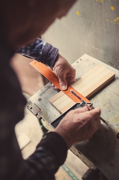 Viejo carpintero trabajando con madera, teñido retro