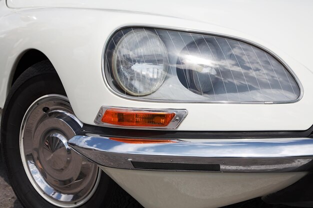 El viejo coche blanco con faros ovalados.