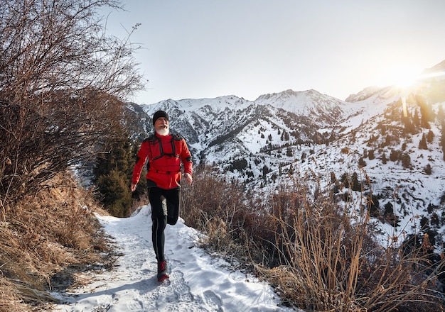 El viejo corre en las montañas en invierno