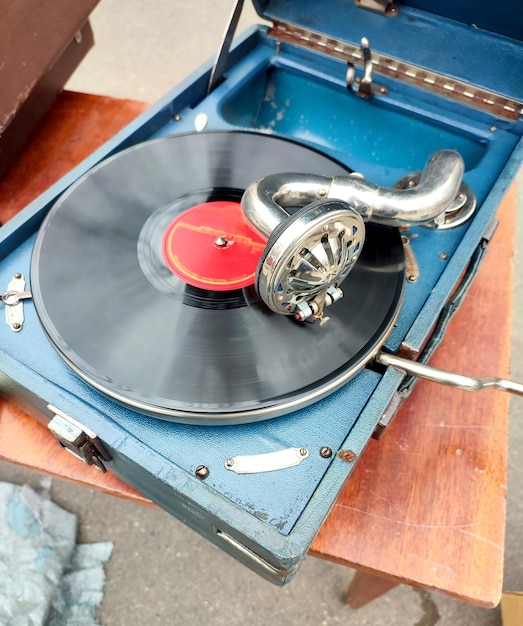 Un viejo disco retro tocando en un viejo gramófono vintage en el mercado de pulgas trabajo de gramófono portátil viejo