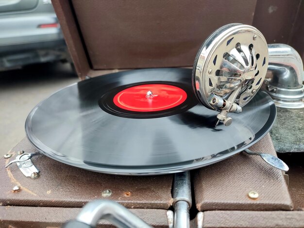 Un viejo disco retro tocando en un viejo gramófono vintage en el mercado de pulgas trabajo de gramófono portátil viejo