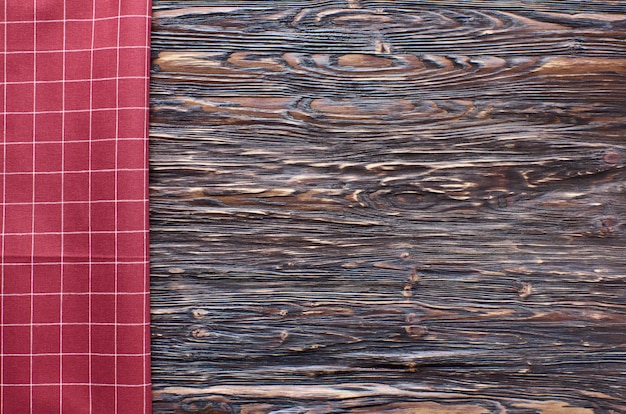 Viejo fondo de madera oscura. Mesa de madera con papel de cocina rojo