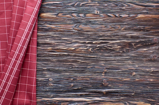 Foto viejo fondo de madera oscura. mesa de madera con papel de cocina rojo