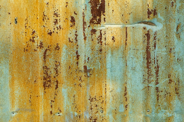 Viejo fondo de metal. Textura de la vieja pintura amarilla verde seca sobre una superficie metálica oxidada