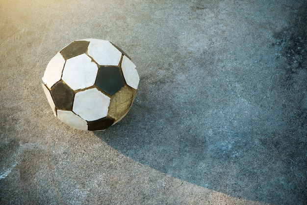 Viejo fútbol en el fondo de hormigón y la sombra de fútbol viejo