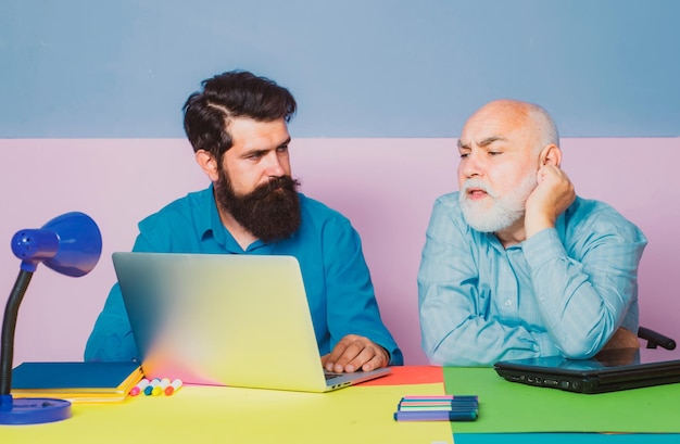 El viejo gerente tiene una conversación amistosa en una reunión con una computadora portátil, un corredor sonriente que consulta a un cliente que muestra una presentación de computadora.