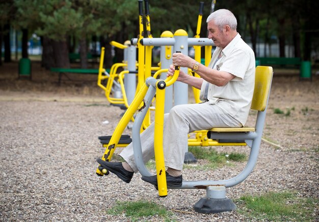 Foto viejo haciendo ejercicios en el gimnasio al aire libre