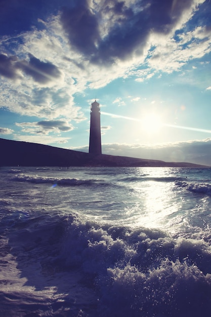 Viejo haz del reflector del faro a través del aire marino.