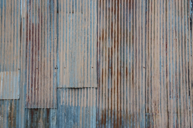 Viejo y hierro oxidado galvaniza la placa en la textura y el color de la casa pobre del tiempo pasado