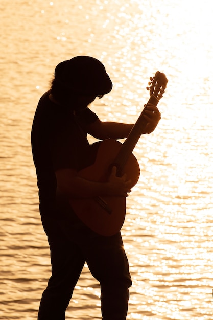 Viejo hombre tocando la guitarra acústica - al aire libre