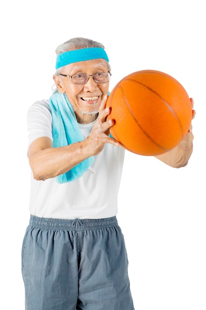 El viejo juega y pasa una pelota de baloncesto en el estudio.