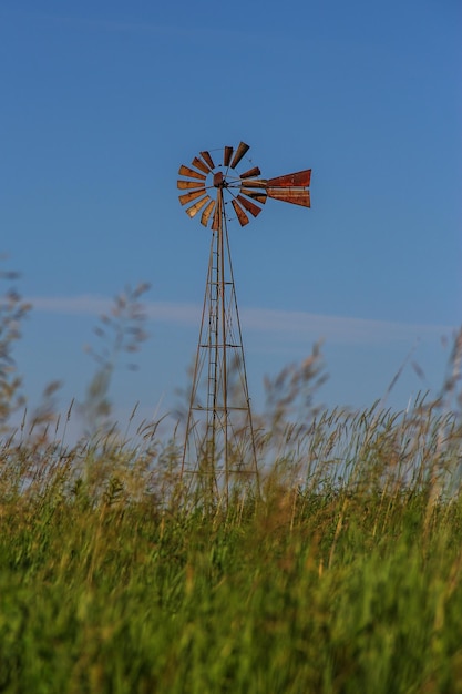 Viejo molino de viento en el campo de hierba contra el cielo