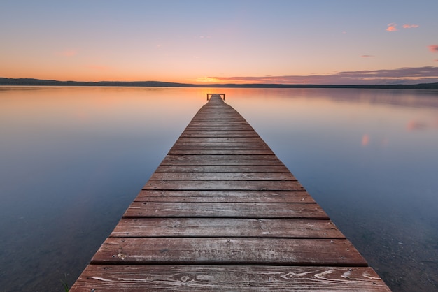 Viejo muelle de madera en puesta de sol