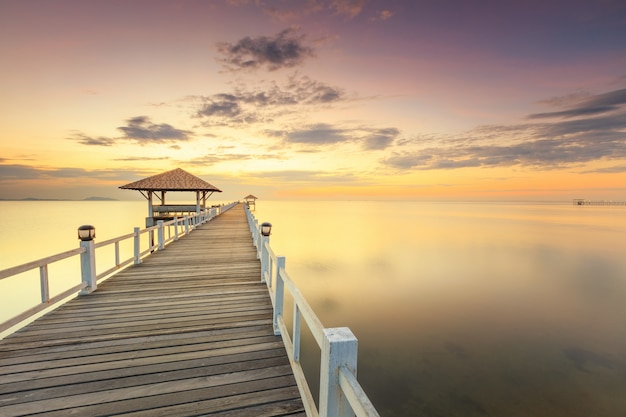 Viejo muelle de puente de madera contra el hermoso cielo del atardecer