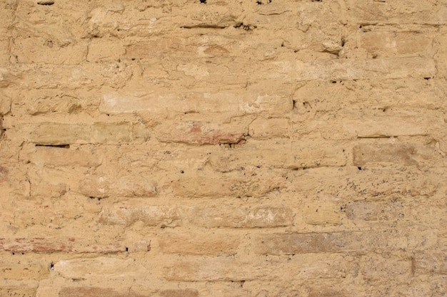 Viejo muro de ladrillo amarillo, en construcción para el fondo. De cerca.