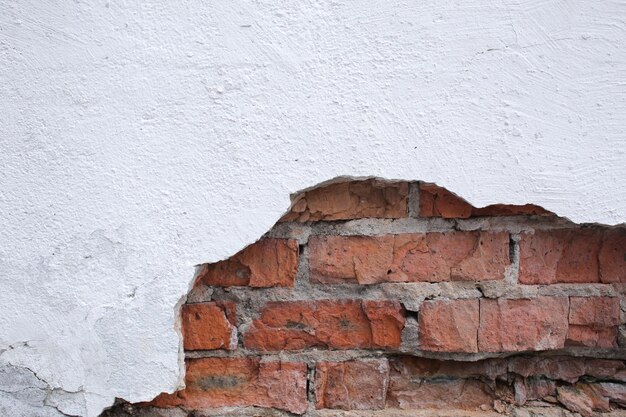 Viejo muro de piedra en mal estado con corrosión y defectos en pantalla completa