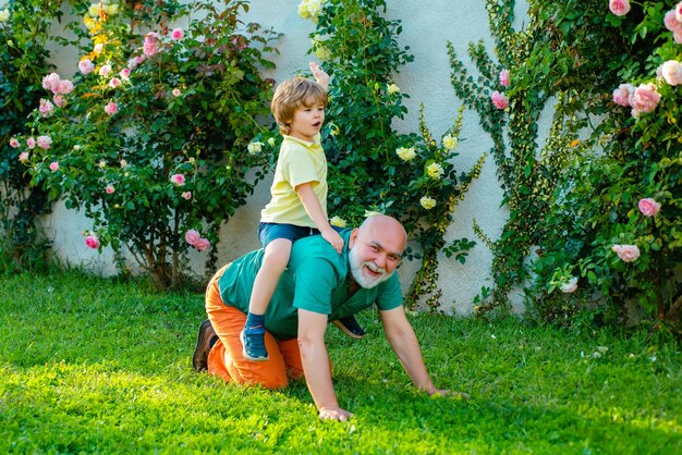 El viejo padre juega con su hijo feliz día del padre feliz padre dando a su hijo un paseo a cuestas sobre sus hombros un