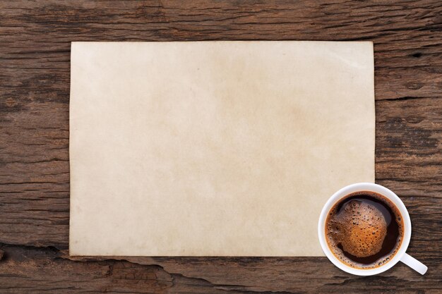 Viejo papel en blanco y una taza de café en madera