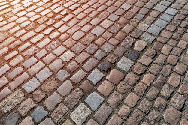 Viejo patrón de adoquines. Textura del adoquín alemán antiguo en el centro de la ciudad. Pequeñas baldosas de granito. Antiguos pavimentos grises.