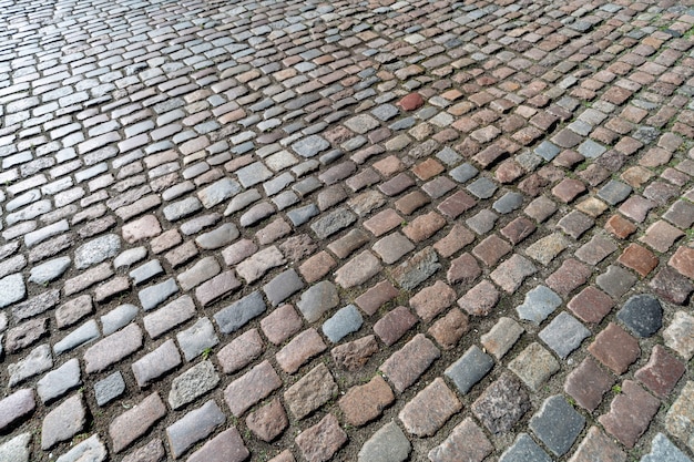 Viejo patrón de adoquines. Textura del adoquín alemán antiguo en el centro de la ciudad. Pequeñas baldosas de granito. Antiguos pavimentos grises.