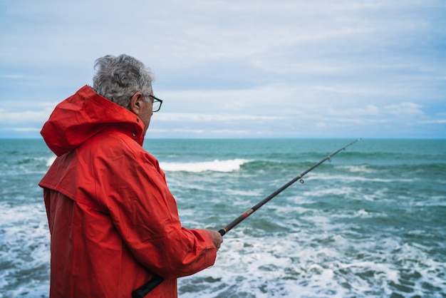 Viejo pescando en el mar