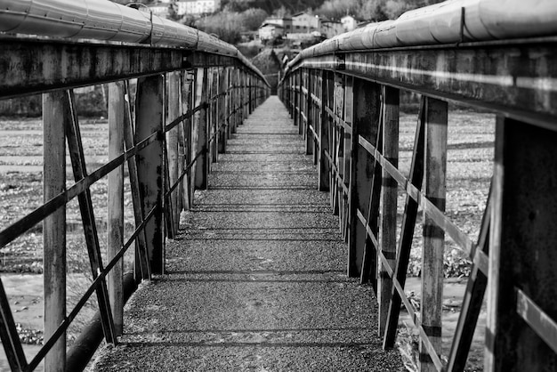 Viejo puente metálico sobre un río en blanco y negro