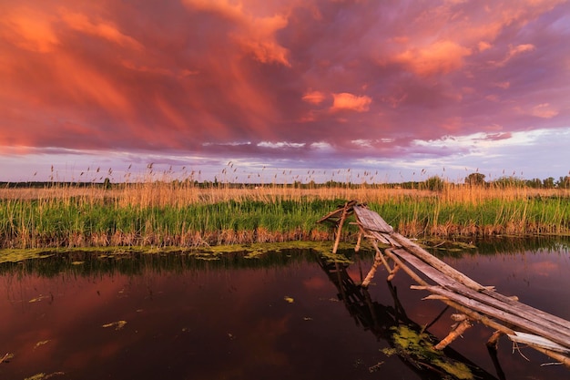 Viejo puente de pesca al atardecer en un pequeño río