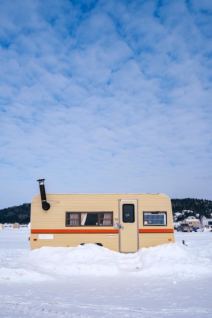 Viejo remolque utilizado como cabaña de pesca en el hielo en el fiordo Saguenay congelado en la Baie, Quebec (Canadá)