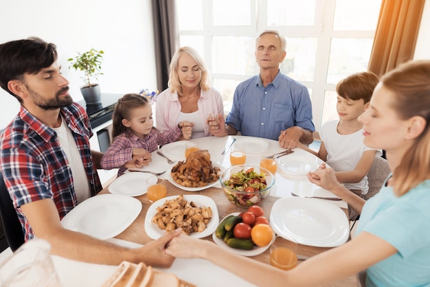 Foto el viejo sobre la mesa y rezando con los ojos cerrados.