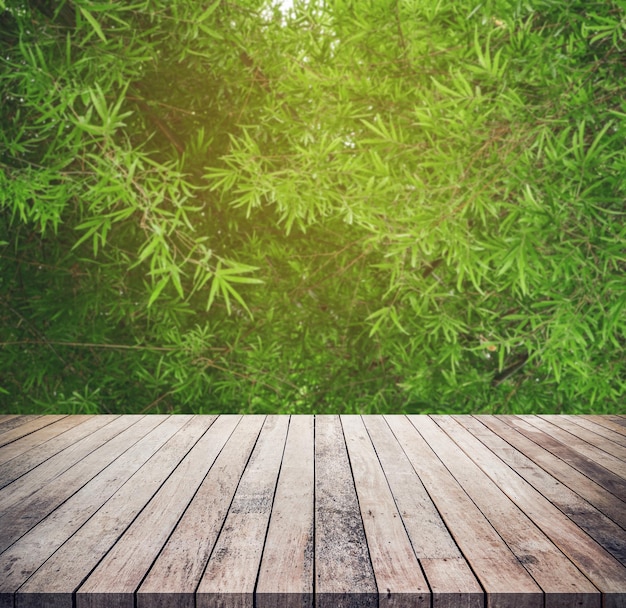 Viejo tablón de madera con fondo de bosque de bambú borroso natural abstracto para exhibición de productos