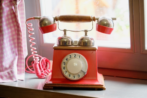 Foto un viejo teléfono de disco de pie en una ventana en la habitación