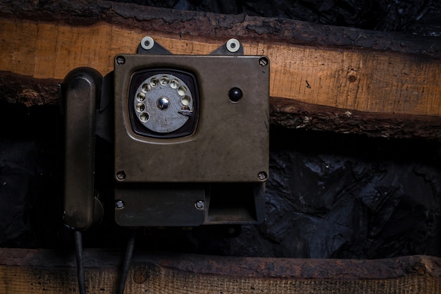 Viejo teléfono sity vintage en una vieja pared de madera para usar en una mina