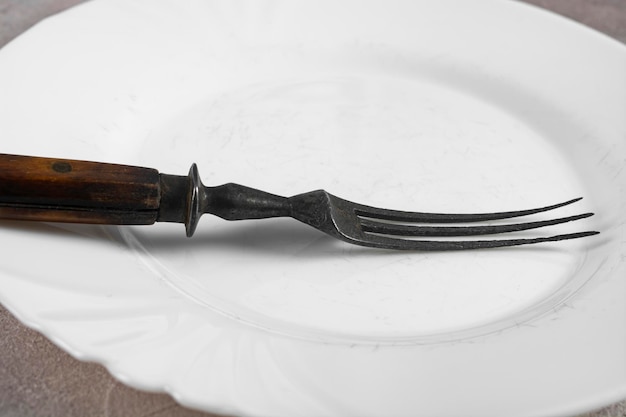 Foto viejo tenedor vintage en un plato blanco