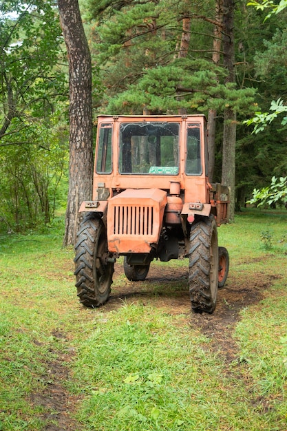 Viejo tractor abandonado en el bosque verde