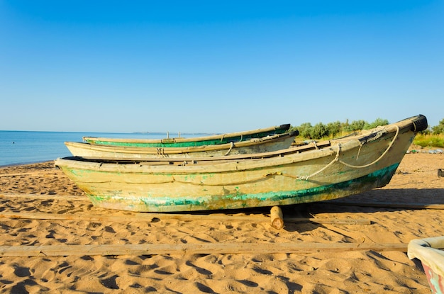 Viejos barcos de pesca en la arena cerca del mar.
