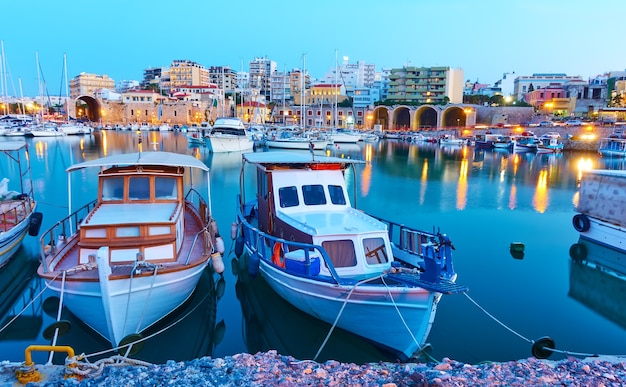 Viejos barcos de pesca en el puerto de Heraklion en la noche, Creta, Grecia