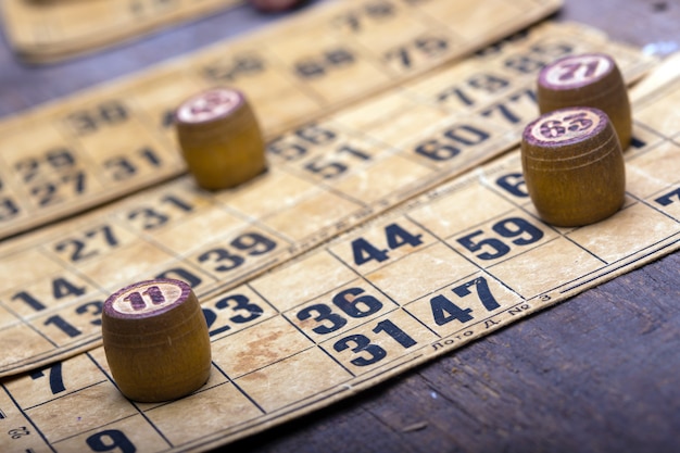 Viejos barriles de lotería de madera y cartas de juego.