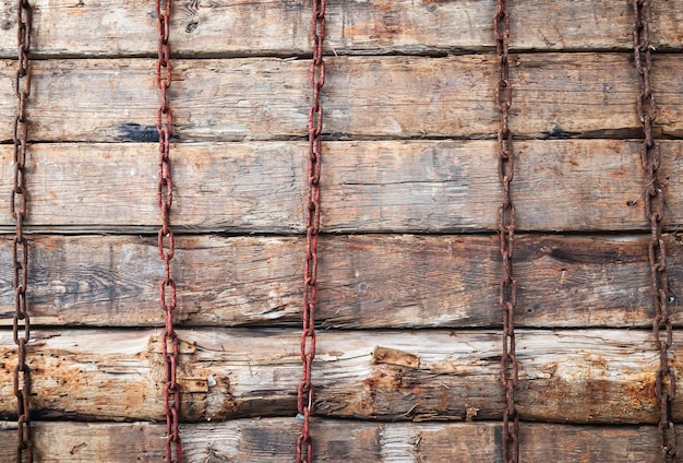 Los viejos bloques de madera se apilan uno encima del otro y se presionan verticalmente con cadenas oxidadas