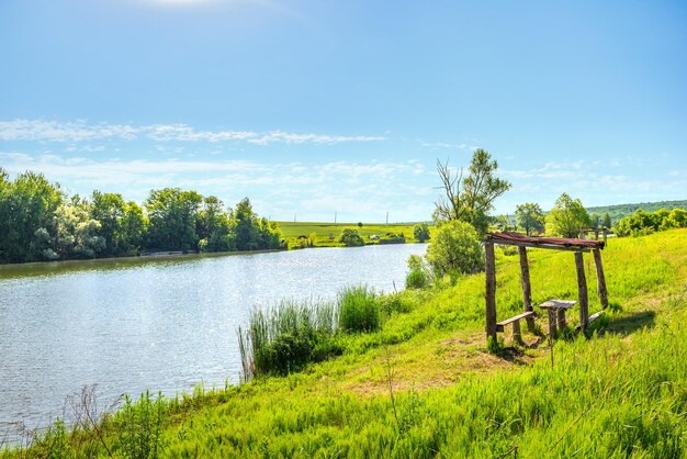 Viejos muebles de picnic en un río tranquilo en verano