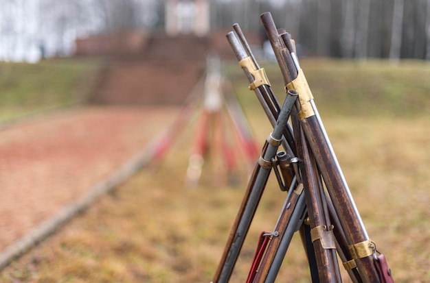 Los viejos rifles están apilados con una choza.