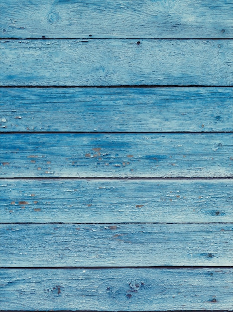 Viejos tablones de madera en mal estado azul con pintura de color agrietado