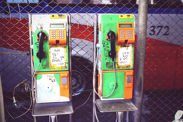 Viejos teléfonos públicos por la valla de la cadena