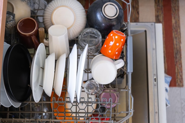 Viel schmutziges Geschirr in der Spülmaschine. Helfen Sie der Gastgeberin bei der Ökonomie und Ökologie beim Reinigen der Küche