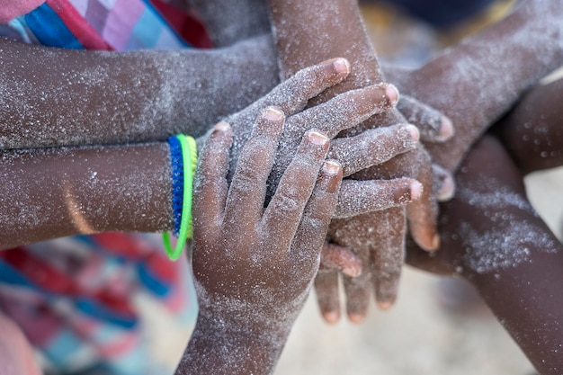 Viele afrikanische Kinderhände verbinden sich am Sandstrand Tansania Afrika