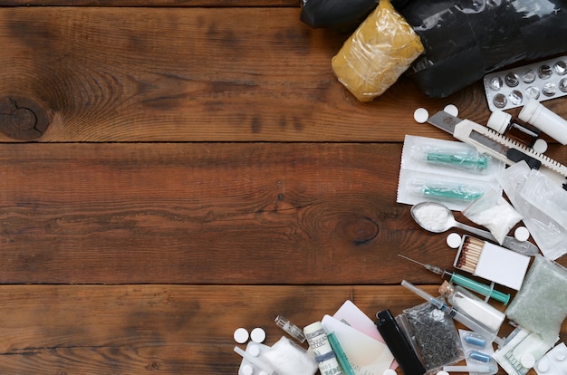 Viele Betäubungsmittel und Vorrichtungen zur Herstellung von Arzneimitteln liegen auf einem alten Holztischhintergrund