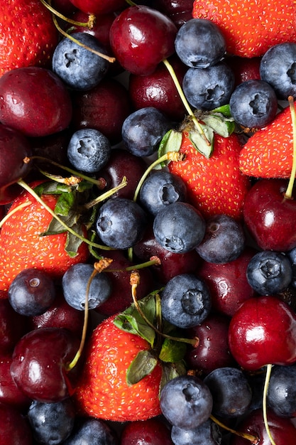 Viele Erdbeeren, Kirschen und Blaubeeren. saftiger sommerhintergrund mit früchten.