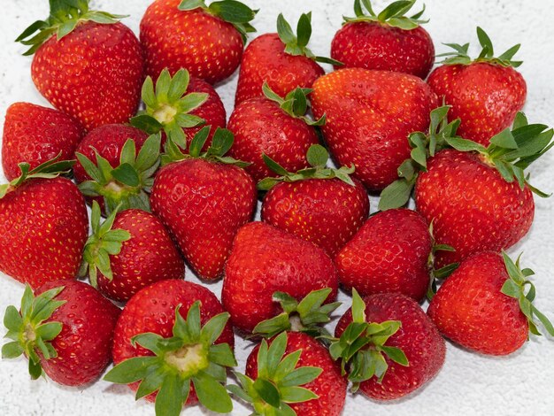 Viele Erdbeeren Nahaufnahme auf weißem Marmorhintergrund