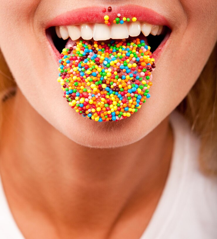 Viele farbige Bonbons auf weiblicher Zunge