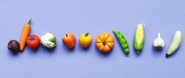 Viele Gemüse und Früchte auf violettem Hintergrund gesundes Ernährungskonzept