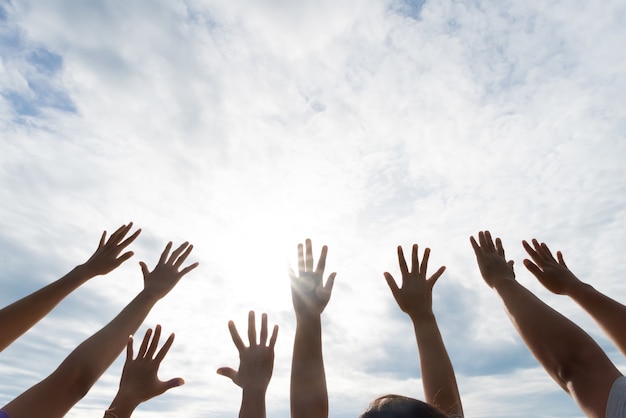 Viele Hände hoben gegen den blauen Himmel an. Freundschaft, Teamwork-Konzept